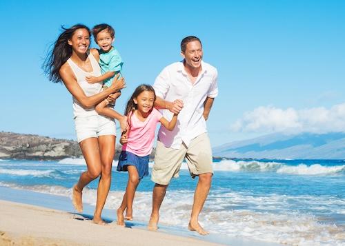 mom, dad, daughter, and son playing on the lihue beach
